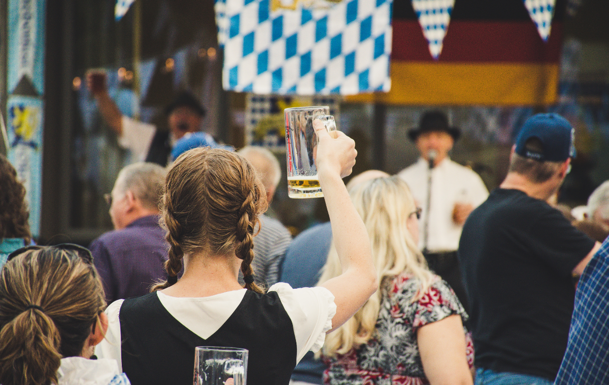 Festival crowd raising steins under Bavarian banners